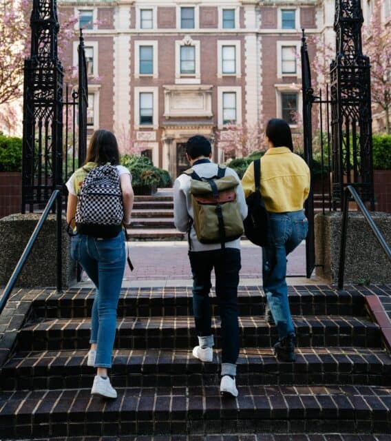 Students walking onto campus, from behind.