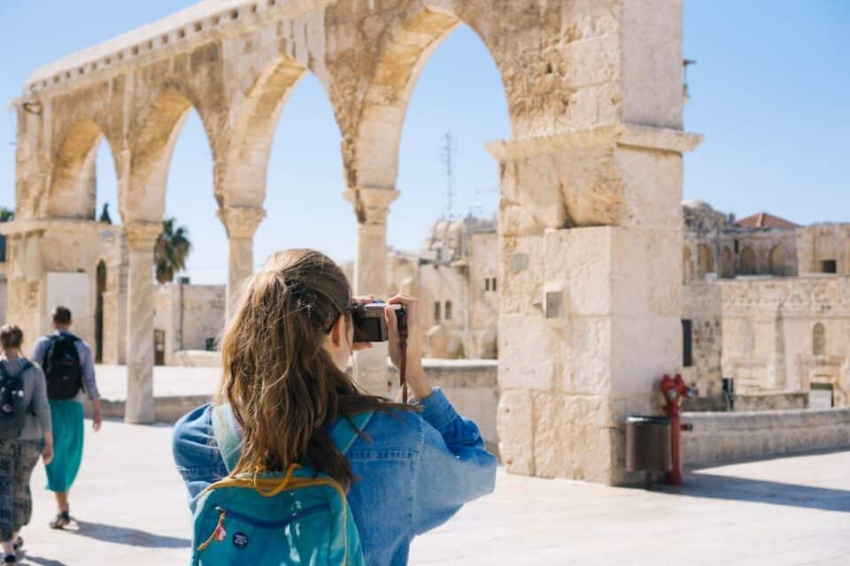 Woman taking photo of ruins.