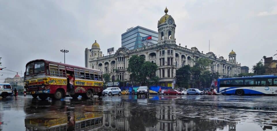 Cars and buses on a wet road in Kolkata, India.