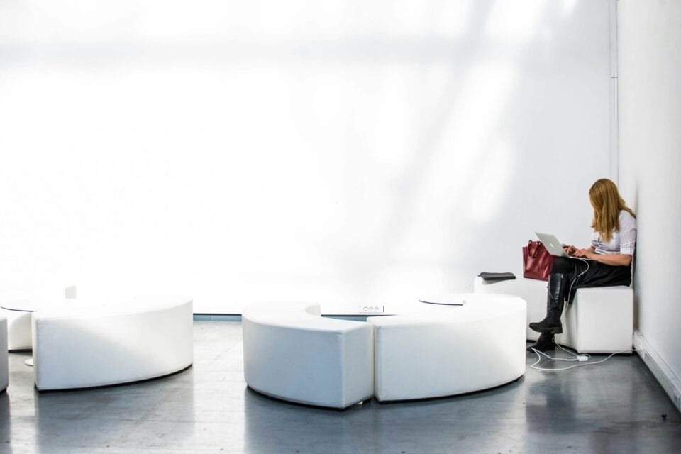 A student sits alone in a white room