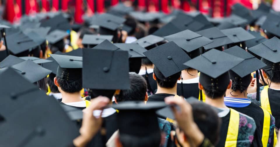 Group of students in graduation caps from behind.