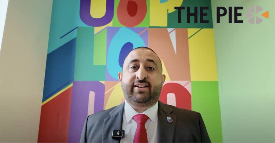 Bobby Mehta speaks to the camera against a colourful backhground