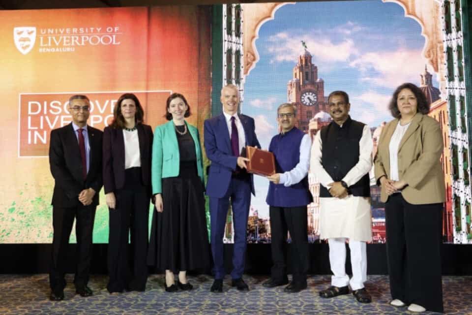Stakeholders gather on stage holding a document