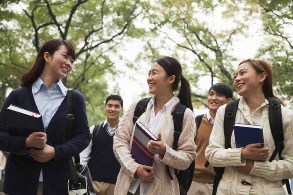 Chinese students walking with books.