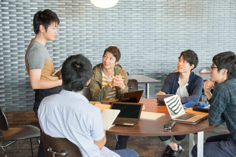 Japanese university students sitting around table.